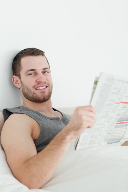 Retrato de un hombre guapo leyendo un periódico