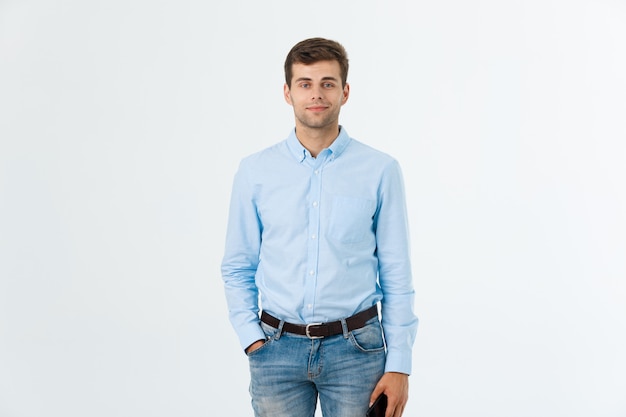 Retrato de hombre guapo de moda feliz en jeans y camisa azul mira a la cámara