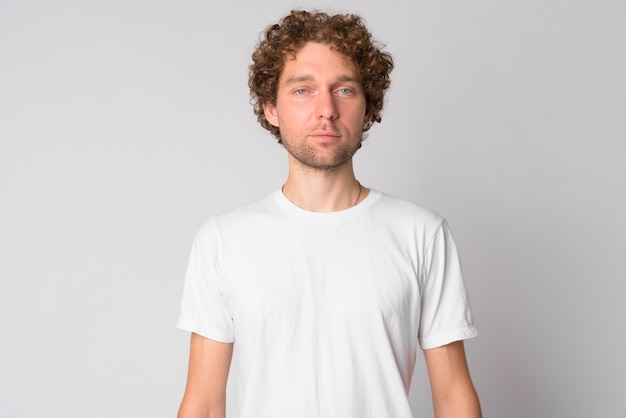 Retrato de hombre guapo con pelo rizado en blanco