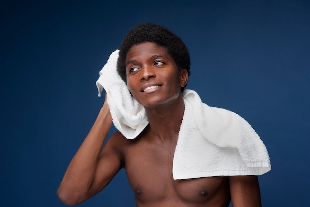 Foto retrato de un hombre guapo secándose el pelo