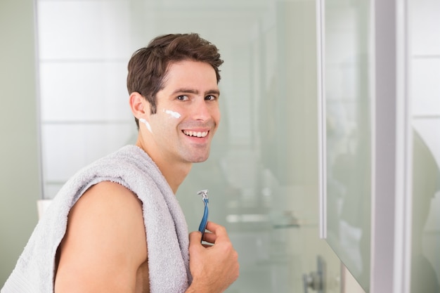 Retrato de hombre guapo sonriente afeitado en el baño