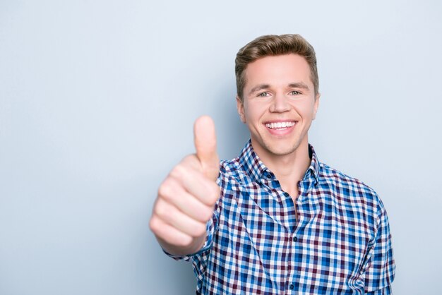 Retrato de hombre guapo sonriente dando pulgares