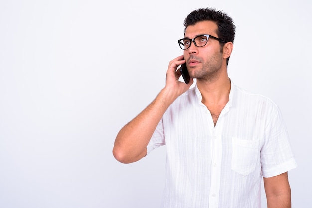 Retrato de hombre guapo turco con anteojos hablando por teléfono