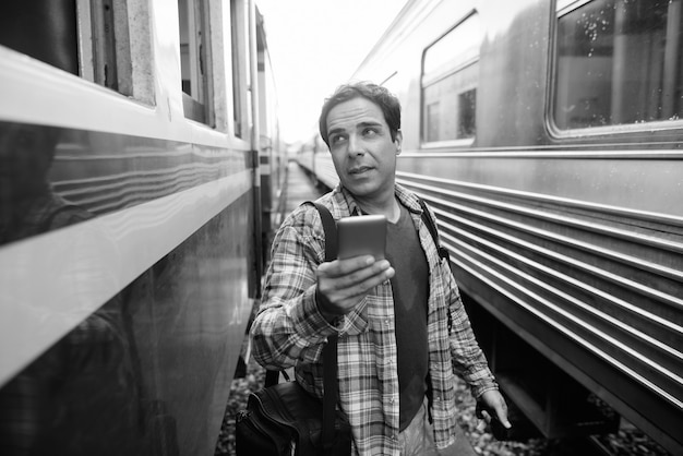 Retrato de hombre guapo turista persa pasar vacaciones y explorar la ciudad de Bangkok en blanco y negro