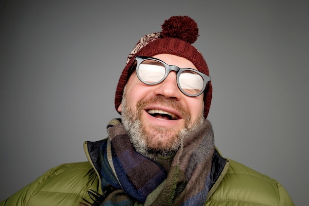 Retrato de hombre hipster maduro con gafas y sombrero posando Sonriente hombre barbudo vistiendo ropa de abrigo para el invierno