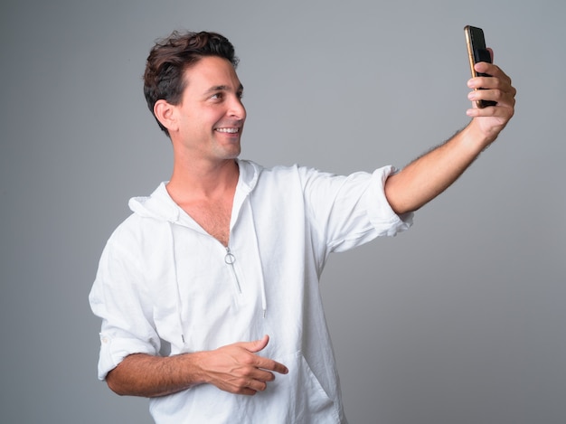 Retrato de hombre hispano guapo feliz tomando selfie