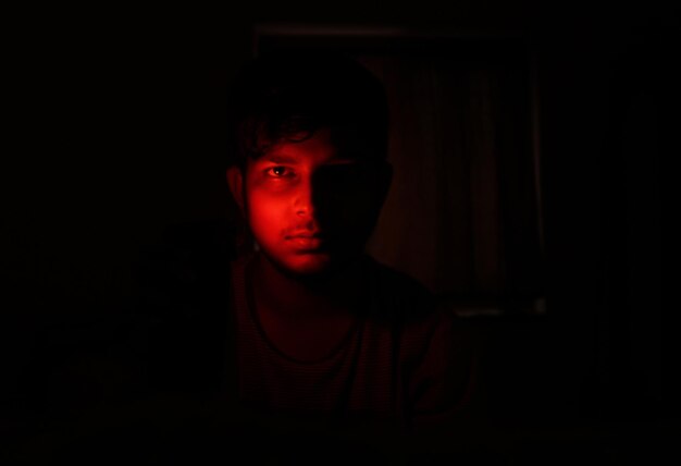 Retrato de un hombre indio en luz roja y fondo oscuro