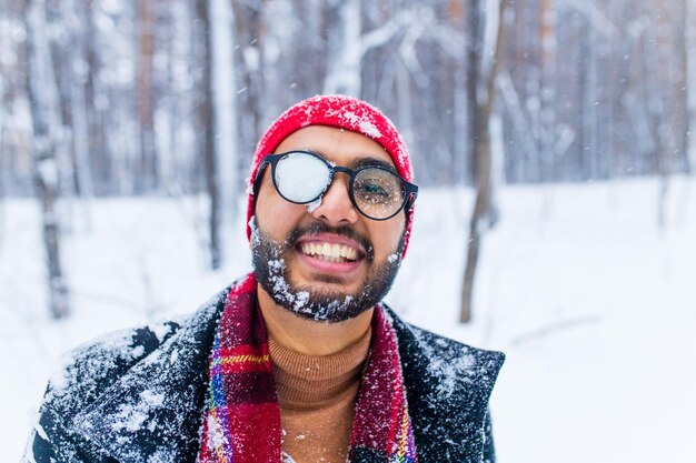 Retrato de un hombre indio con sombrero rojo tirando nieve en la cara