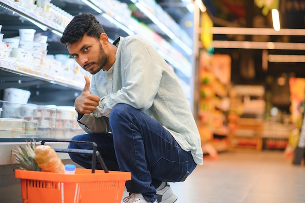 retrato de un hombre indio en una tienda de comestibles con una actitud positiva