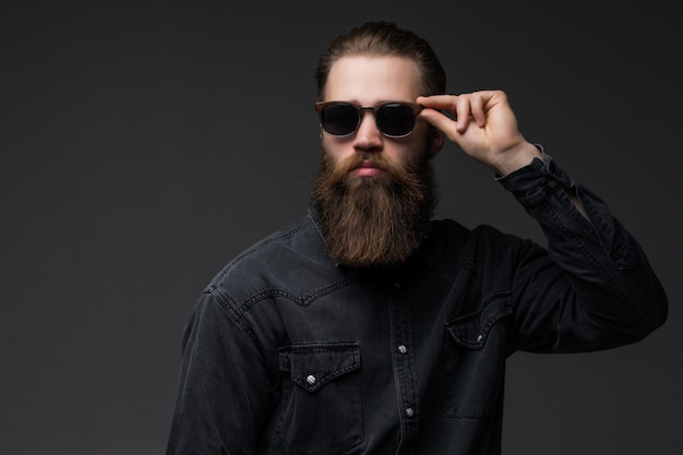 Retrato de hombre joven barbudo guapo s con expresión seria con gafas de sol