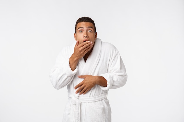 Retrato de hombre joven sin camisa guapo mirando emocionado mientras está de pie contra el blanco