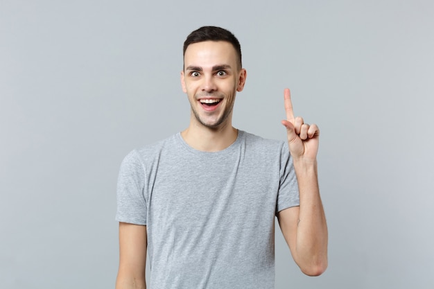 Retrato de hombre joven emocionado en ropa casual, levantando el dedo índice con una gran idea nueva