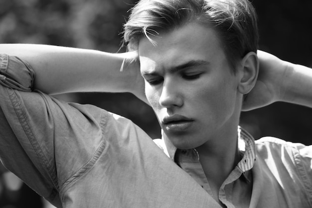 Retrato de hombre joven con estilo en el parque de verano al aire libre