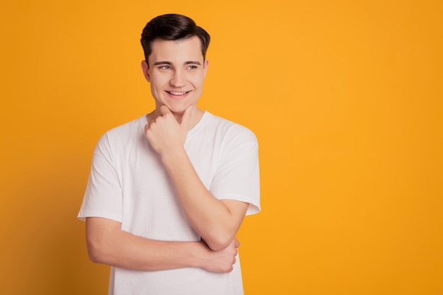 Retrato de hombre joven feliz de mente soñando mirar espacio vacío aislado sobre fondo amarillo