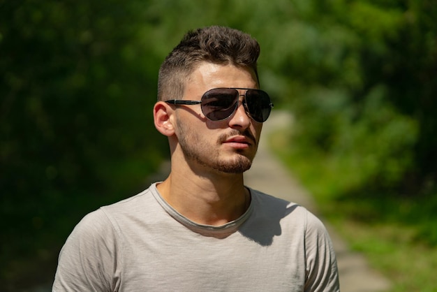 Retrato de hombre joven guapo con estilo. Chico de moda en gafas de sol.