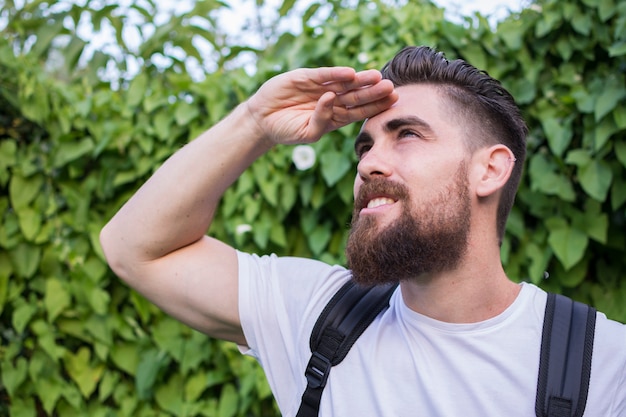 Retrato hombre joven, hermoso y aventurero con su mochila