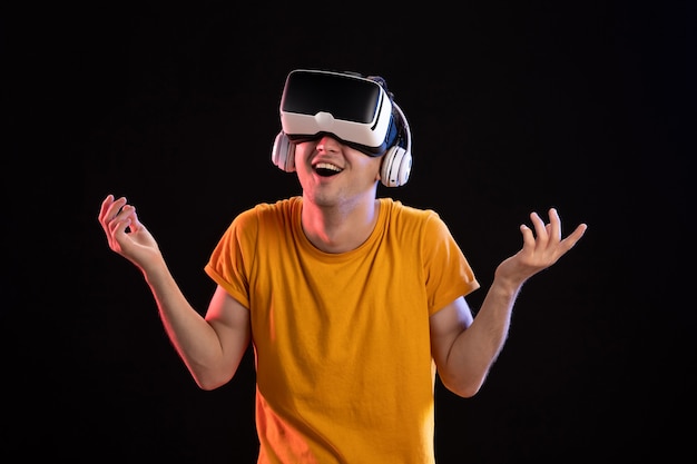 Retrato de hombre joven jugando vr en auriculares en el escritorio oscuro tecnología de visión visual de juegos d