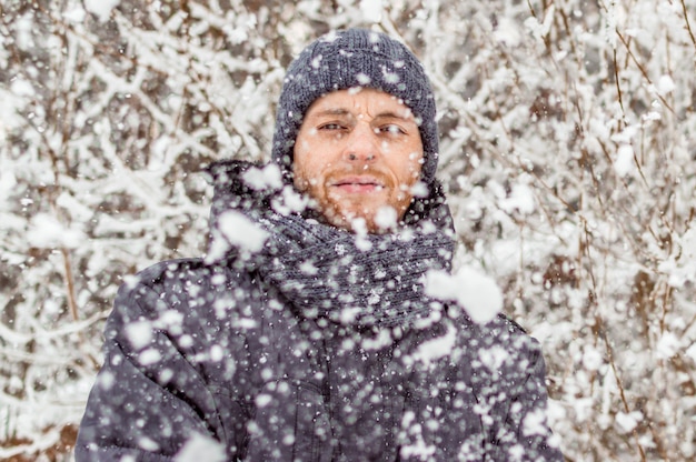 Retrato de un hombre joven en un primer plano del bosque de invierno. concepto de nevadas