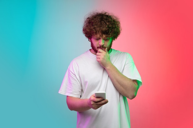 Retrato de hombre joven sobre fondo de estudio degradado en neón