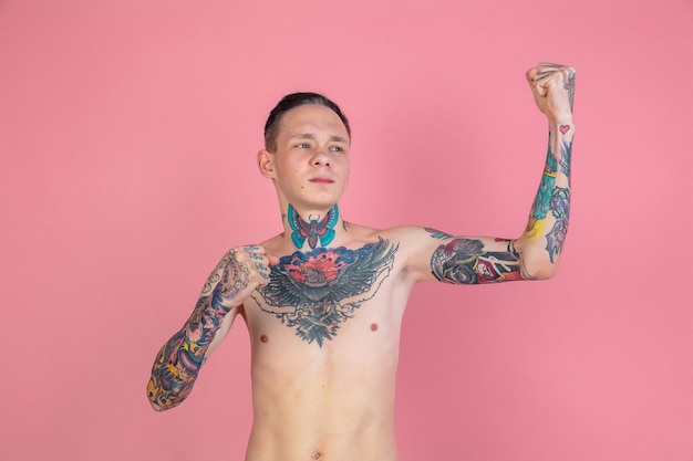 Foto retrato de hombre joven con tatuajes con gesto fuerte