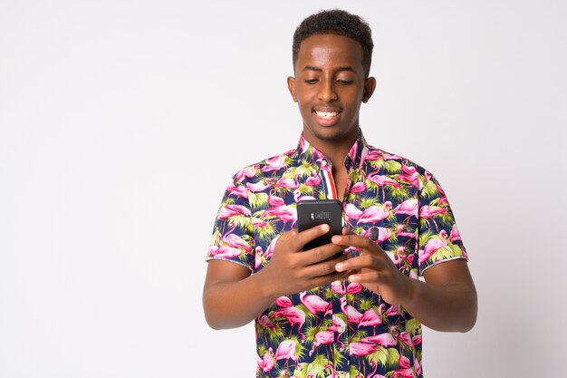 Retrato de hombre joven turista africano con pelo afro contra la pared blanca