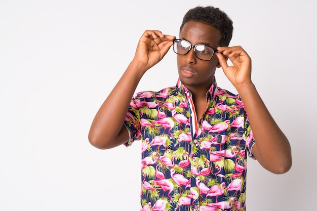 Retrato de hombre joven turista africano con pelo afro contra la pared blanca