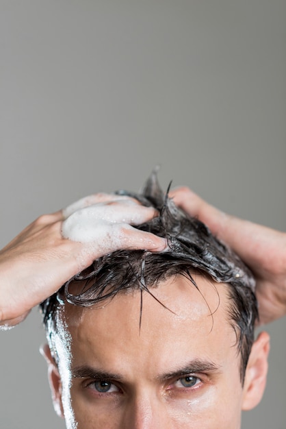 Foto retrato de hombre lavando su cabello con espacio de copia