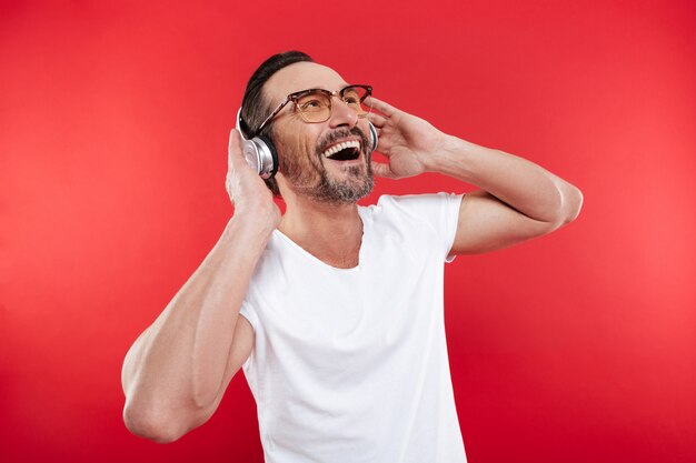 Retrato de un hombre maduro alegre escuchando música