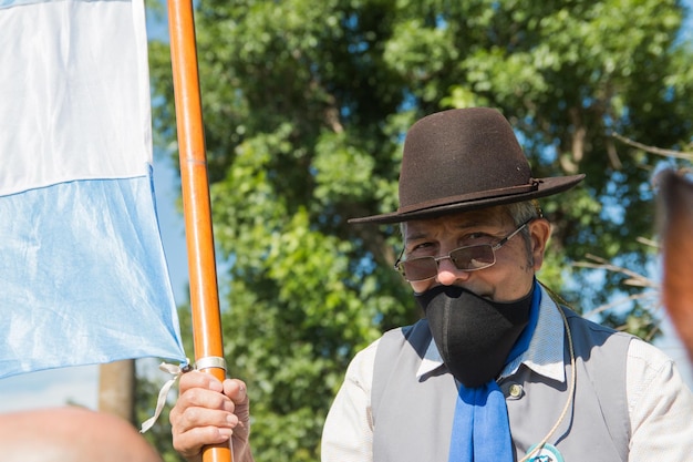 Foto retrato de un hombre maduro con sombrero y gafas de sol sosteniendo una bandera