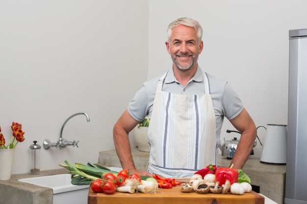 Retrato de un hombre maduro con verduras en la cocina