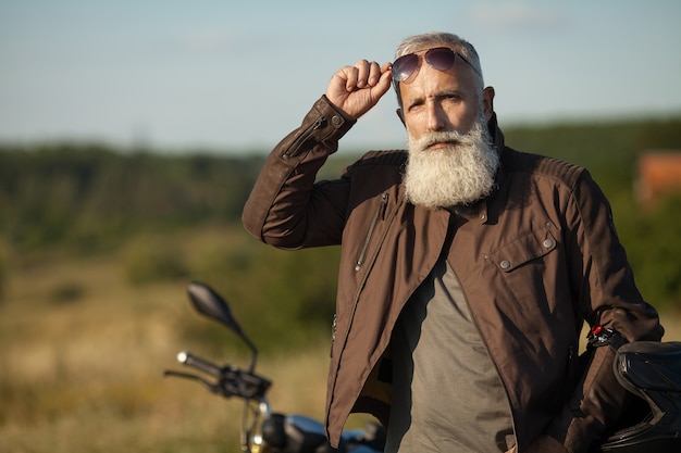 Retrato de un hombre mayor al aire libre. Viejo retrato de motorista.