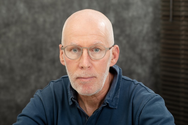 Retrato de un hombre mayor con barba y gafas