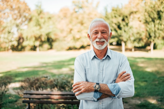 Foto retrato de un hombre mayor sonriente en el parque.