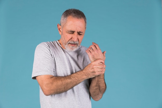 Retrato de un hombre mayor sosteniendo su muñeca lesionada