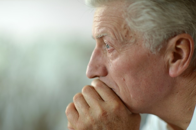 Retrato de un hombre mayor triste en casa