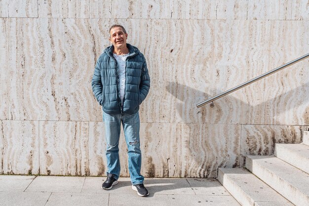 Retrato de un hombre de mediana edad positivo contra una pared de mármol de fondo con escalones