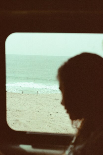 Retrato de un hombre mirando a la orilla del mar contra el cielo