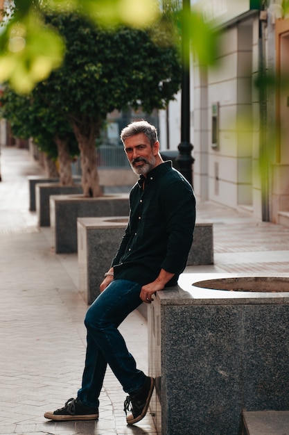 Retrato de un hombre modelo de unos 50 años mirando a la cámara en la calle