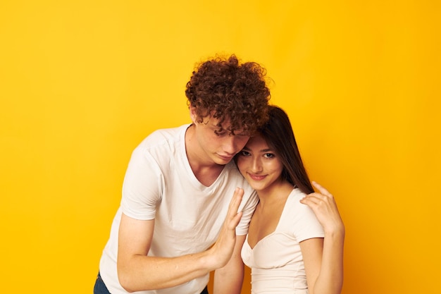 Retrato de un hombre y una mujer abrazo amor emoción fondo amarillo inalterado