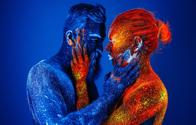 Retrato de un hombre y una mujer con barba pintados en polvo ultravioleta.