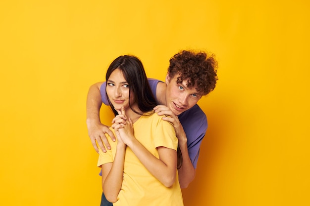 Retrato de un hombre y una mujer en camisetas coloridas posando amistad fondo amarillo divertido inalterado