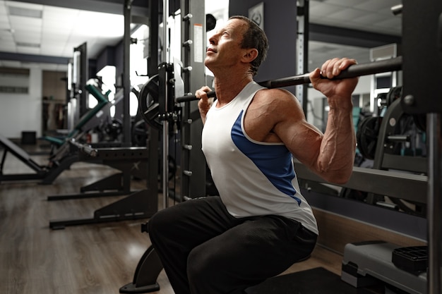 Retrato de un hombre musculoso senior en un gimnasio