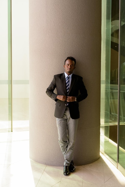 Retrato de un hombre de negocios africano con traje y corbata al aire libre en la ciudad