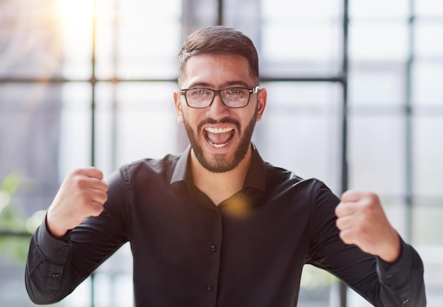 Retrato de un hombre de negocios alegre que celebra su éxito