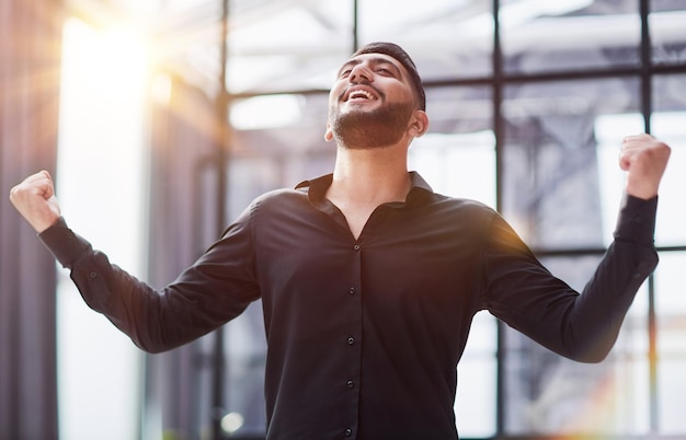 Retrato de un hombre de negocios alegre que celebra su éxito