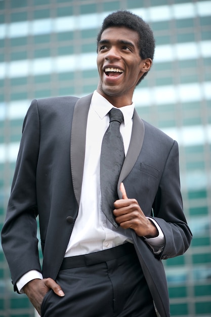 Retrato de un hombre de negocios americano africano feliz que sonríe afuera