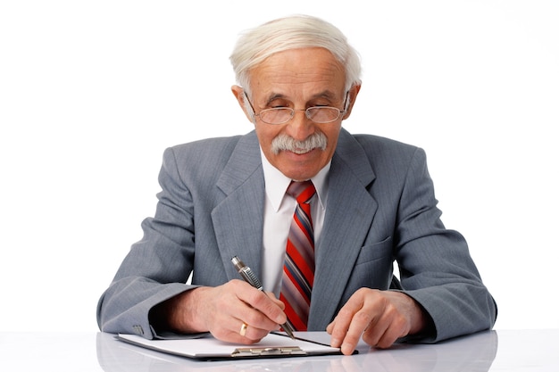 Retrato de un hombre de negocios anciano escribiendo algo en el documento en blanco.