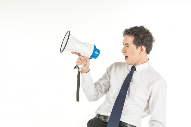 Foto el retrato del hombre de negocios asiático joven elegante que lleva la camisa blanca grita con el megáfono del altavoz inalámbrico en fondo blanco aislado y copia el espacio.