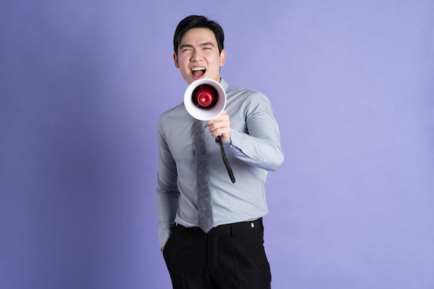 Foto retrato de un hombre de negocios asiático posando sobre un fondo púrpura