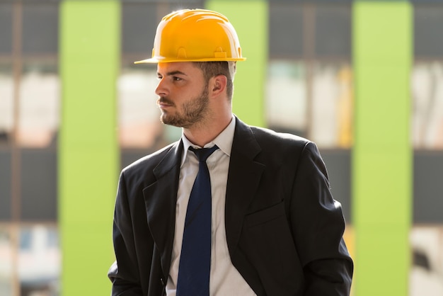 Retrato de hombre de negocios con casco amarillo en construcción